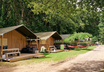 Safari-telte ved Villatent Wood på Camping Domaine du Logis i Frankrig, omgivet af skov og afslapning.