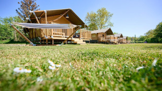 Tiendas safari Villatent Nomad en el resort de vacaciones de Bronzen Emmer, Países Bajos, con césped verde.