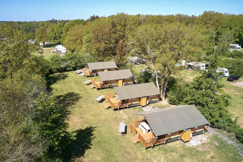 Vista aérea de tiendas safari Villatent Nomad en el resort De Bronzen Emmer en los Países Bajos rodeado de naturaleza.