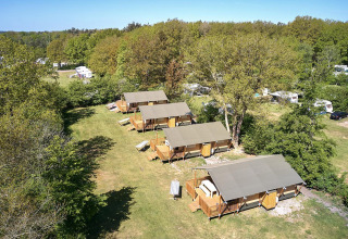 Vista aérea de tiendas safari Villatent Nomad en el resort De Bronzen Emmer en los Países Bajos rodeado de naturaleza.
