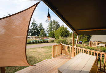 Vista desde la cabaña Villatent Outback en Camping Le Sequoia, Francia, con terraza de madera y piscina.