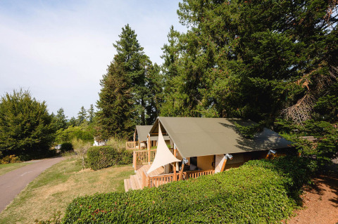 Villatent Outback al Camping Le Sequoia in Francia, tende da glamping immerse nel verde e tra alberi alti.