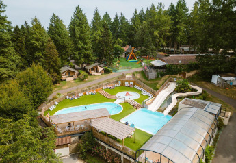 Aerial view of Villatent Outback at Camping Le Sequoia in France, with pools, slides, and surrounding forest.
