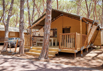 Lodge Villatent Outback au Camping Village Baia Blu La Tortuga en Italie, entouré de grands pins.