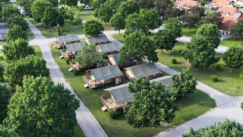 Vista aérea del Villatent Outback lodge con tiendas espaciosas, árboles verdes y caminos organizando el camping.