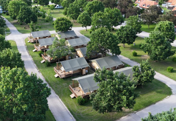 Luchtfoto van Villatent Outback lodge met ruime tenten, groene bomen en paden op het kampeerterrein.