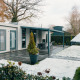 Veluwe Villa op Holiday park De Boshoek in Nederland, met sneeuw op het gazon en moderne veranda