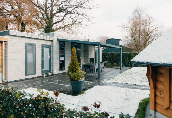 Veluwe Villa en el Holiday park De Boshoek, Países Bajos, rodeada de césped nevado y terraza moderna