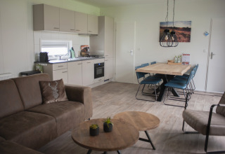 Moderne leefruimte en keuken in Veluwe Villa op Holiday park De Boshoek, Nederland, met eettafel.