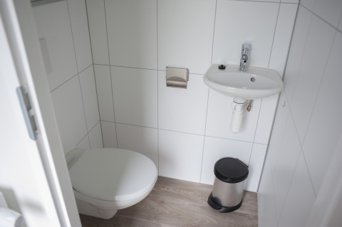 Moderne compacte badkamer in Veluwe Villa, Holiday park De Boshoek, Nederland, met toilet en wastafel.