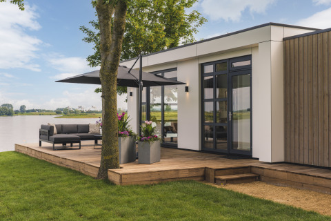Moderne lodge Villa Maritiem bij MarinaPark Bad Nederrijn in Nederland met terras en uitzicht op het water.