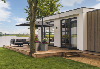 Moderne Villa Maritiem Lodge im MarinaPark Bad Nederrijn, Niederlande, mit Terrasse und Seeblick.