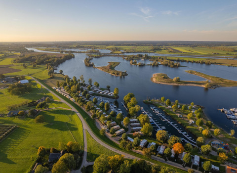 Luftfoto af Villa Maritiem ved MarinaPark Bad Nederrijn i Holland med sø, grønne marker og bådehavn.