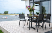 Terras van Villa Maritiem aan MarinaPark Bad Nederrijn, Nederland, met tafel, stoelen en rivierzicht.