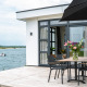 Moderne lodge aan het water met terras, bloementafel en uitzicht op boot bij Villa Maritiem, MarinaPark Bad Nederrijn.