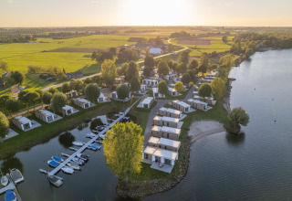 Vista aérea de Villa Maritiem en MarinaPark Bad Nederrijn, Países Bajos, cabañas junto al lago con campo verde.