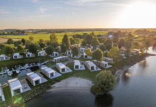 Vista aérea de los lodges Villa Maritiem en MarinaPark Bad Nederrijn, Países Bajos, junto al agua y prados verdes.