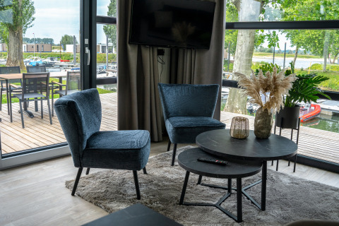 Soggiorno moderno nella Villa Maritiem, MarinaPark Bad Nederrijn, con vista sul porto turistico e arredo accogliente.