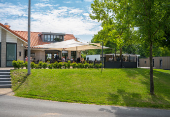 Outdoor seating area at Villa Maritiem lodge in MarinaPark Bad Nederrijn, Netherlands, with sunny terrace and greenery.
