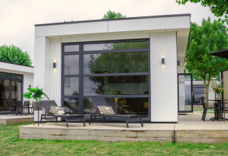 Moderno lodge Villa Maritiem al MarinaPark Bad Nederrijn nei Paesi Bassi, con terrazza e lettini.