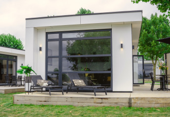 Lodge moderno Villa Maritiem en MarinaPark Bad Nederrijn, Países Bajos, con tumbonas y terraza amplia.
