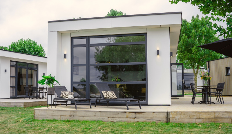 Lodge moderno Villa Maritiem en MarinaPark Bad Nederrijn, Países Bajos, con tumbonas y terraza amplia.