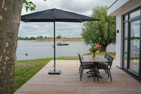Terraza en Villa Maritiem, MarinaPark Bad Nederrijn, Países Bajos, con vistas al río y mobiliario moderno.
