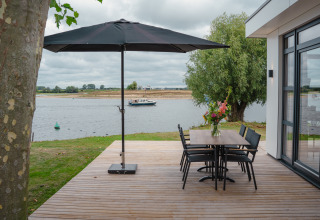 Terraza en Villa Maritiem, MarinaPark Bad Nederrijn, Países Bajos, con vistas al río y mobiliario moderno.