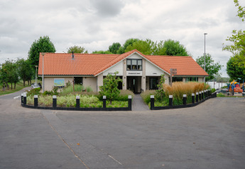 Foto van lodge Villa Maritiem bij MarinaPark Bad Nederrijn in Nederland, met bloemen en bomen rondom.