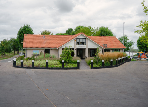 Foto del lodge Villa Maritiem a MarinaPark Bad Nederrijn nei Paesi Bassi, con giardino rigoglioso davanti.