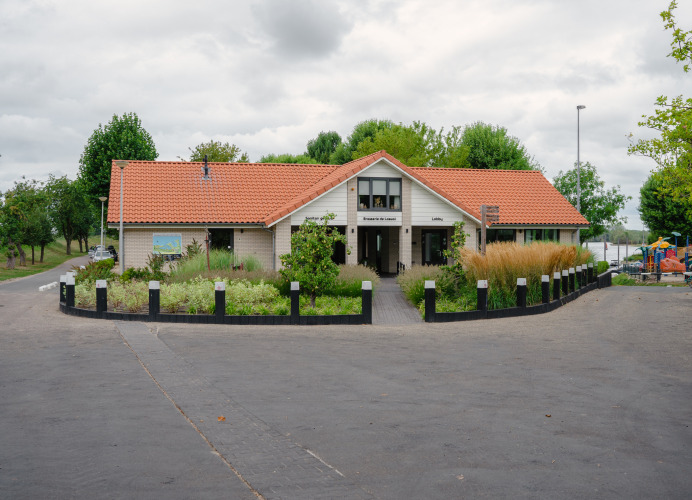 Foto del lodge Villa Maritiem en MarinaPark Bad Nederrijn, Países Bajos, rodeado de vegetación y árboles.