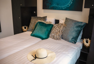 Acogedor dormitorio en la Villa Maritiem del MarinaPark Bad Nederrijn, Países Bajos, con elegantes cojines.