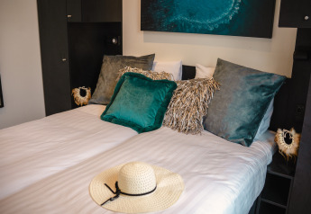 Acogedor dormitorio en la Villa Maritiem del MarinaPark Bad Nederrijn, Países Bajos, con elegantes cojines.