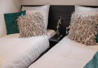 Deux lits simples avec coussins modernes à la Villa Maritiem, MarinaPark Bad Nederrijn, aux Pays-Bas.