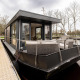 Moderne woonboot Offingawier bij Welcome In - Friesland, Nederland, aangemeerd naast een steiger.
