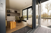 Innenansicht eines modernen Hausboots in Welcome In - Friesland, Niederlande, mit Blick aufs Wasser.