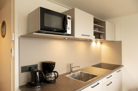 Cocina moderna con microondas, cafetera, hervidor y fregadero en Houseboat Offingawier, Friesland.