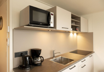 Cocina moderna con microondas, cafetera, hervidor y fregadero en Houseboat Offingawier, Friesland.