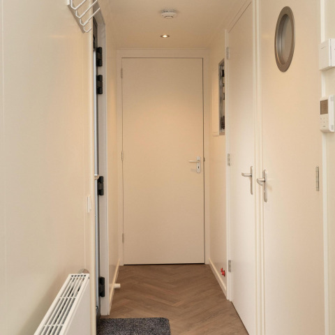 Flur im Hausboot Houseboat Offingawier mit weißen Wänden und Türen, gesehen bei Welcome In - Friesland.
