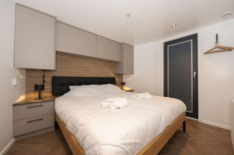 Camera moderna sulla Houseboat Offingawier a Welcome In - Friesland, Paesi Bassi, con letto matrimoniale e arredo elegante.