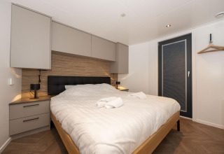 Camera moderna sulla Houseboat Offingawier a Welcome In - Friesland, Paesi Bassi, con letto matrimoniale e arredo elegante.