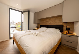 Schlafzimmer auf dem Hausboot Offingawier bei Welcome In - Friesland, Niederlande, mit Wasserblick.