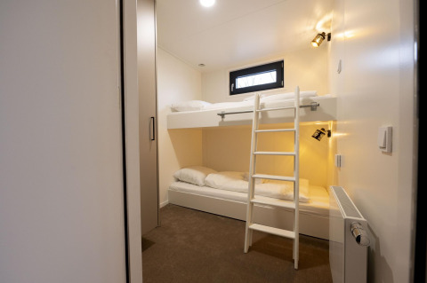 Literas modernas en una habitación luminosa de Houseboat Offingawier en Welcome In - Friesland, Países Bajos.