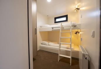 Literas modernas en una habitación luminosa de Houseboat Offingawier en Welcome In - Friesland, Países Bajos.