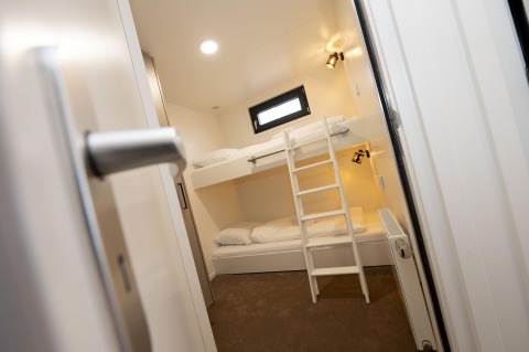 Habitación moderna con literas y escalera en Houseboat Offingawier de Welcome In - Friesland, Países Bajos.