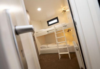 Habitación moderna con literas y escalera en Houseboat Offingawier de Welcome In - Friesland, Países Bajos.