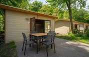 Udendørsbillede af Forest Lodge-hytte ved Het Amsterdamse Bos i Holland med borde og stole på terrassen.