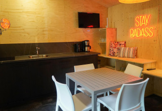 Cocina y comedor modernos en Forest Lodge, Het Amsterdamse Bos, Países Bajos, con letrero neón 'STAY BADASS'.