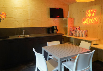 Moderne køkken- og spiseplads i Forest Lodge, Het Amsterdamse Bos, med neon 'STAY BADASS' skilt.
