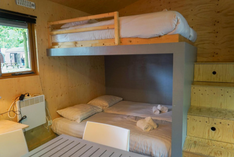 Innenansicht der Forest Lodge im Het Amsterdamse Bos mit Etagenbetten und Holzverkleidung.